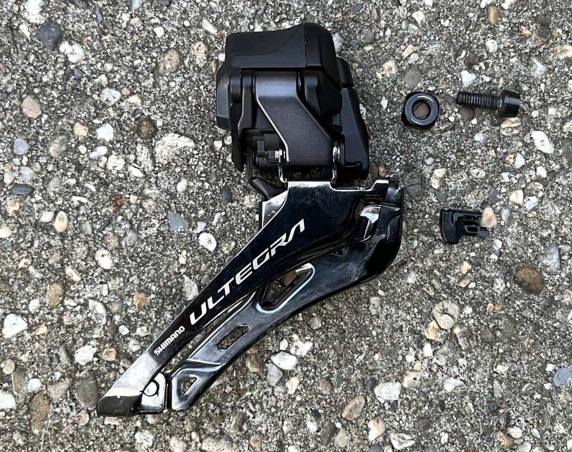 The 12-speed Ultegra Front Derailleur comes with a bolt and washer, a wire cover, and the support plate (not pictured)